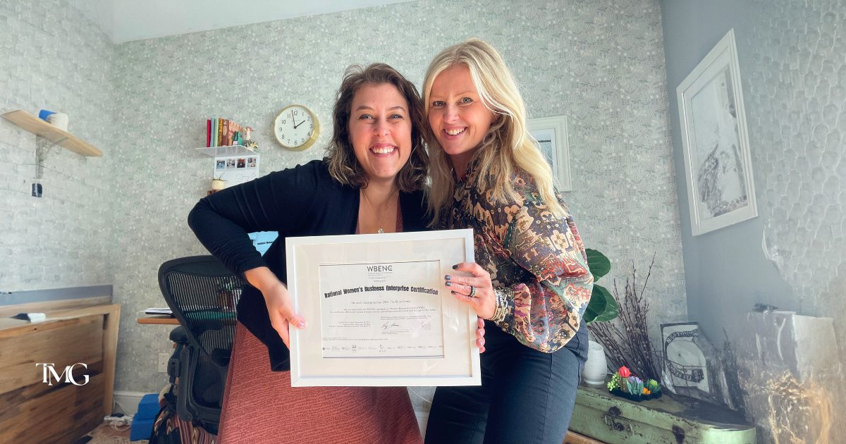 The previous owner of the Molo Group Katelyn Strumolo and the Marketing Director Cristalle Gleason holding the certified By the Women’s Business Enterprise National Council certification.
