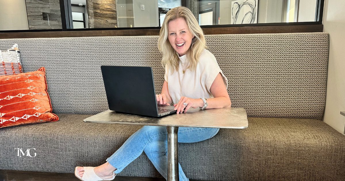 Cristalle Gleason, owner of TMG Marketing Partners, smiling while working—embodying the purpose-driven brand refresh and leadership behind the rebrand