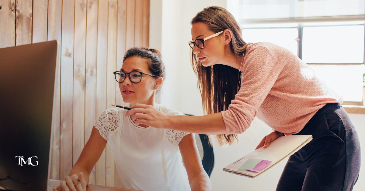 Two women discussing GDPR compliance strategies, reflecting TMG Marketing Partners’ expertise in data protection guidance. The TMG logo is visible, symbolizing trusted insights on GDPR requirements.