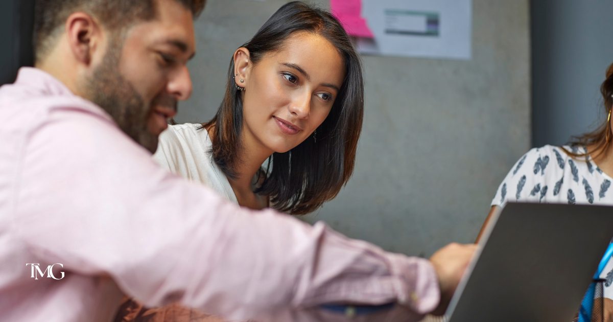 Two professionals collaborate over a laptop in a modern workspace, embodying the principles of Growth Driven Design through strategy and user-focused discussion.