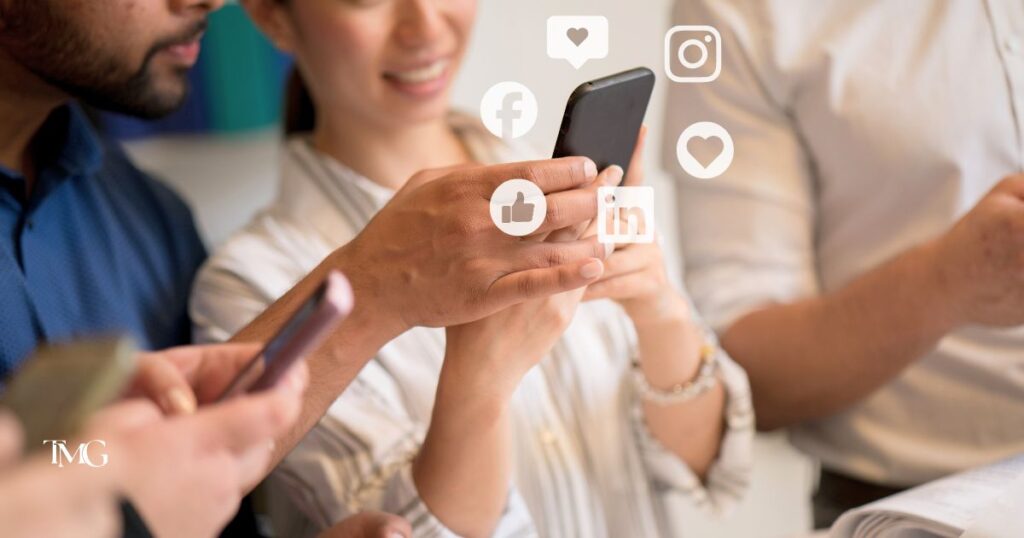 Close-up of diverse hands holding smartphones with floating social media icons for Facebook, Instagram, LinkedIn, and likes, representing popular social media platforms.