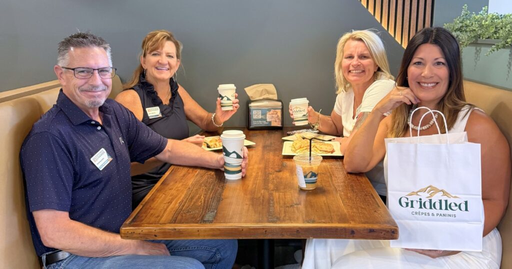 Four guests celebrate the Castle Rock restaurant grand opening with coffee, crêpes, and a Griddled gift bag.