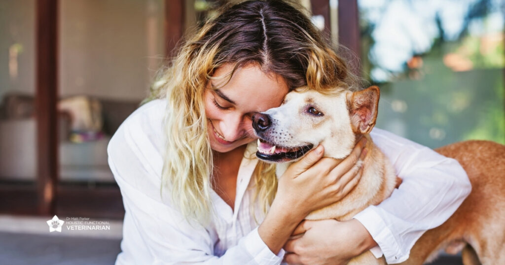 Woman affectionately hugging her dog, featured in branded photography for Dr. Matt Parker, Holistic Functional Veterinarian.
